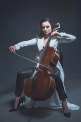 Beautiful woman in a white coat plays the cello © Антон Фрунзе