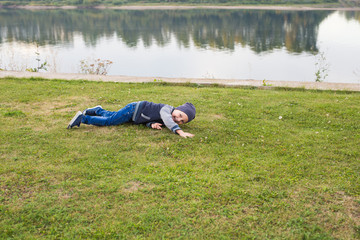 Children and childhood concept - Smiling little boy laying on the grass