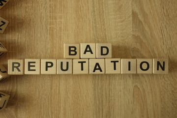 Bad reputation text from wooden blocks on desk