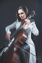 Beautiful woman in a white coat plays the cello