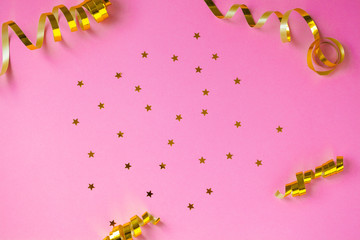 Golden decorations and sparkles on pink background