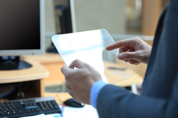 Businessman hand with transparent tablet and pc computer.