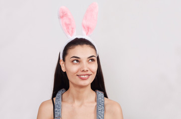 Festive bunny and eggs season. happy modern woman in Easter bunny ears isolated on pink background