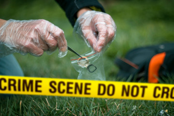 Crime scene expert collecting evidence at the murder location. Law and police concept. Selective focus