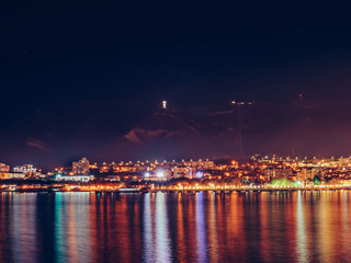 Night Gelendzhik landscape with reflection of city lights in sea water, copy space