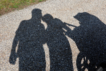 Family with baby carriage in the shade
