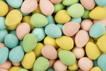 Top view on mini chocolate easter eggs candies as a background. Copy space for your text.