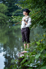 Boyish looking girl fishing outdoors old school