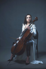 Beautiful woman in a white coat plays the cello