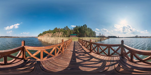 full seamless hdri spherical panorama 360 degrees angle view on wooden pier of wide lake in sunny...
