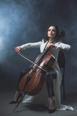 Beautiful woman in a white coat plays the cello