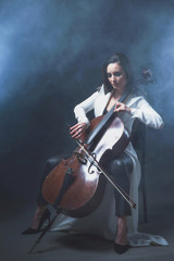 Beautiful woman in a white coat plays the cello