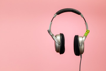 Headphones wrapped with duct tape on a pink background