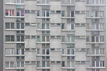 Windows of an apartment building, symmetrical frames in a gray house. many rooms in one house. modern housing construction.