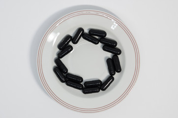 Medical black pills in a circle