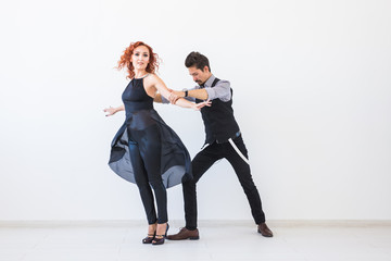 Naklejka premium Social dance, kizomba, tango, salsa, people concept - beautiful couple dancing bachata on white background with copy space