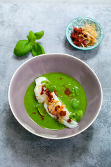 Butter poached cod with green peas, spinach and basil veloute, crispy chorizo and shallot