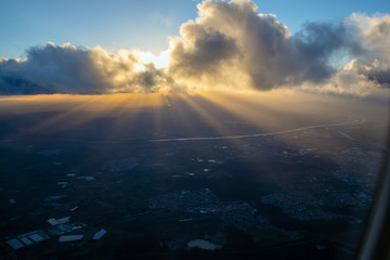 Beams of sun going through cloud onto evening land