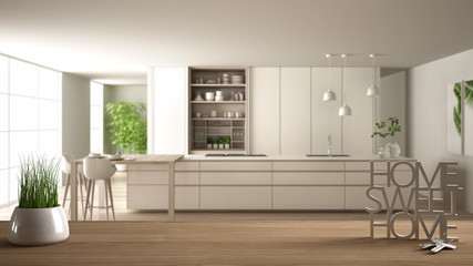 Wooden table, desk or shelf with potted grass plant, house keys and 3D letters home sweet home, over white and wooden kitchen, architecture interior design, copy space background