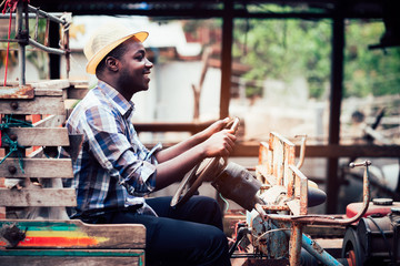 Obraz na płótnie Canvas African farmer drive small tractor on the countryside