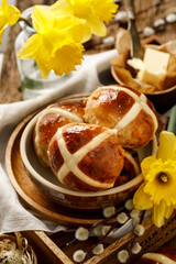 Hot cross buns, freshly baked hot cross buns in a ceramic bowl on a wooden rustic table . Traditional easter food