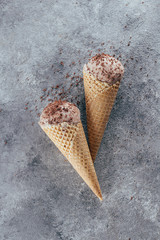 Summer Food Dessert Background. Chocolate ice cream in waffle cones on gray concrete table background. Copy space, top view