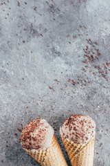 Summer Food Dessert Background. Chocolate ice cream in waffle cones on gray concrete table background. Copy space, top view