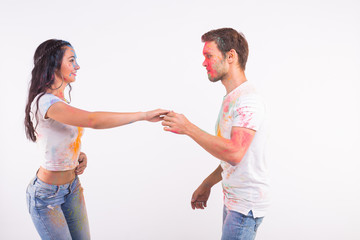 Festival of holi, social dance, friendship - young people playing with colors at the festival of holi and dancing bachata or kizomba on white background