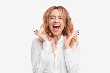 Portrait of young pretty surprised and wow woman with opened mouth standing with open palms, isolated on white background 