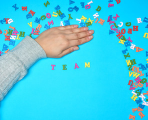 female hand and multicolored wooden letters of the English alphabet