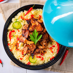 Tajin with couscous, vegetables and meat on white background