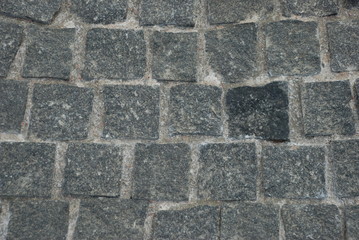 texture of the pavement laid out of granite stone. granite of gray and dark gray color, granite surface is rough