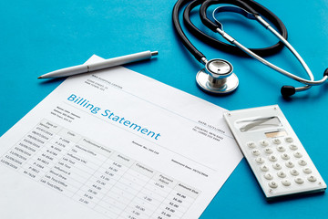 medical treatment bill, calculator and phonendoscope on blue background