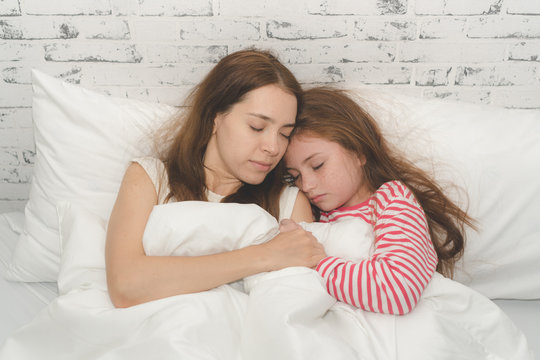 Mom and daughter slepp together.