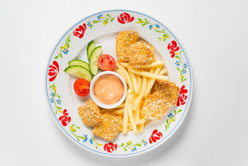 chicken nuggets with french fries and sauce on the white background