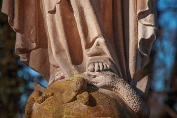 Religious symbol of Christianity: Virgin Mary stands foot on the snake as a symbol of the victory of good over evil. Fragment of antique statue. © zwiebackesser