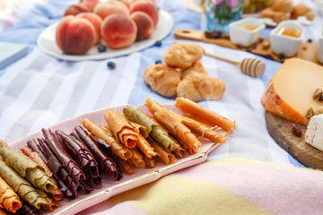 Summer picnic blanket with tasty food and snacks on it. Summer weekends