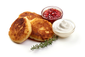 Cheesecakes from cottage cheese with jam and sour cream, close-up, isolated on white background