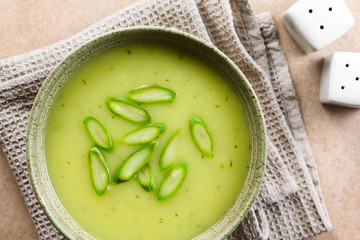 Cream of green asparagus soup in bowl, garnished with sliced asparagus on top, photographed overhead (Selective Focus, Focus on the soup)