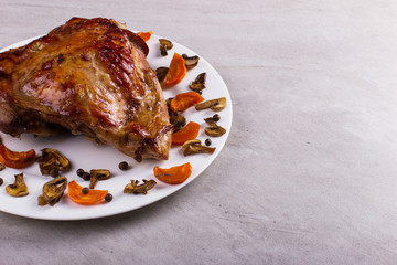 Thigh turkey baked in the oven with spices on a white plate on the tabletop. Healthy food. Thanksgiving dinner.