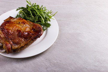 Thigh turkey baked in the oven with spices on a white plate on the tabletop. Healthy food. Thanksgiving dinner.