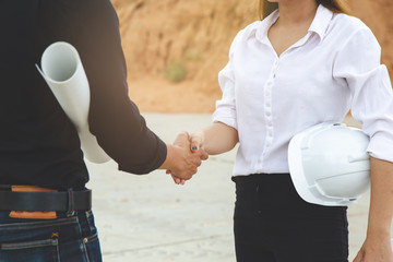 Successful deal, Female architect shaking hands with client in construction site after confirm...