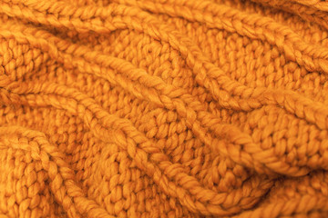 close-up, macro crocheted, wool products. warm, cozy blanket, sweater made of large woolen thread of orange color. winter texture pattern