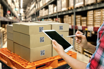 Fototapeta Industrial 4.0 , Augmented reality and smart logistic concept. Hand holding tablet with AR application for check order pick time around the world and supply chain in smart factory background. obraz