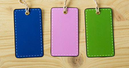 Multicolored blank label price tag on a background of light wood. Country style.
