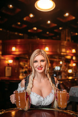 Sexy waitress in retro uniform holds mugs of beer