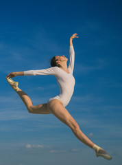 Fototapeta premium Graceful beauty. Concert performance dance. Young ballerina jumping on blue sky. Classic dance style. Cute ballet dancer. Pretty woman in dance wear. Practicing art of classical ballet. Ballet class