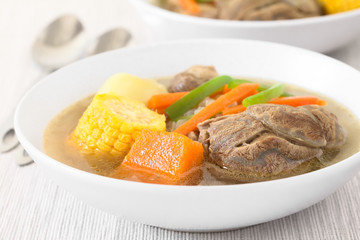 Traditional Chilean Cazuela de Vacuno or Cazuela de Carne, beef soup with potato, corn, pumpkin, carrot, bell pepper, onion and rice (Selective Focus on the front of the meat and the pumpkin)