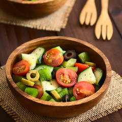 Fresh salad of black and green olives, cherry tomato, green bell pepper and cucumber, photographed with natural light (Selective Focus in the middle of the salad)