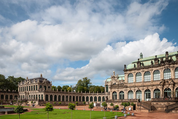 Obraz premium View of the square in Zwinger gallery from steps of Old Masters Picture Gallery towards French and Rampant pavilions at Dresden, Saxony, Germany against astonishing clouds in blue sky
